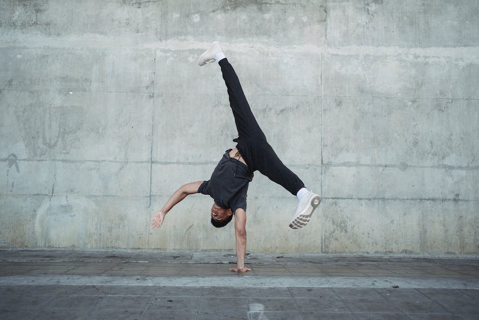 Strong man breakdancing on sidewalk of city